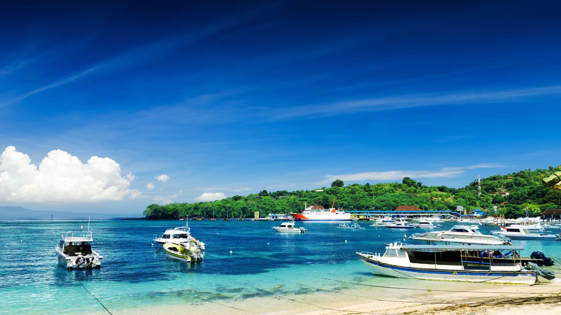 Boats anchored in the turquoise bay at Padang Bai Harbour, Bali